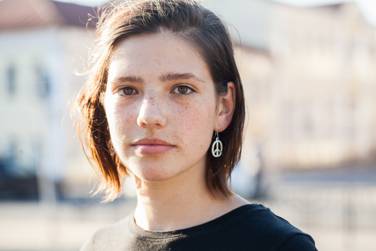 teenage girl with peace sign earrings
