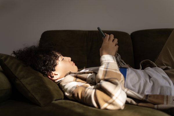 teenage boy reading about Screen Time and Anxiety in Teens on phone
