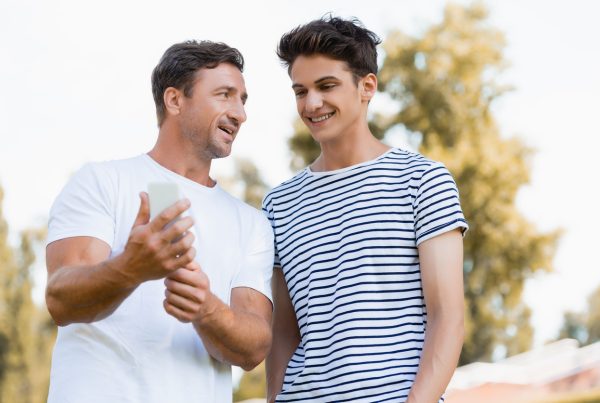 father and son laughing together after father learned about the dos and don'ts of helping teens with depression