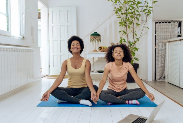 mom and daughter on yoga mat, exploring the benefits of yoga for teenage anxiety