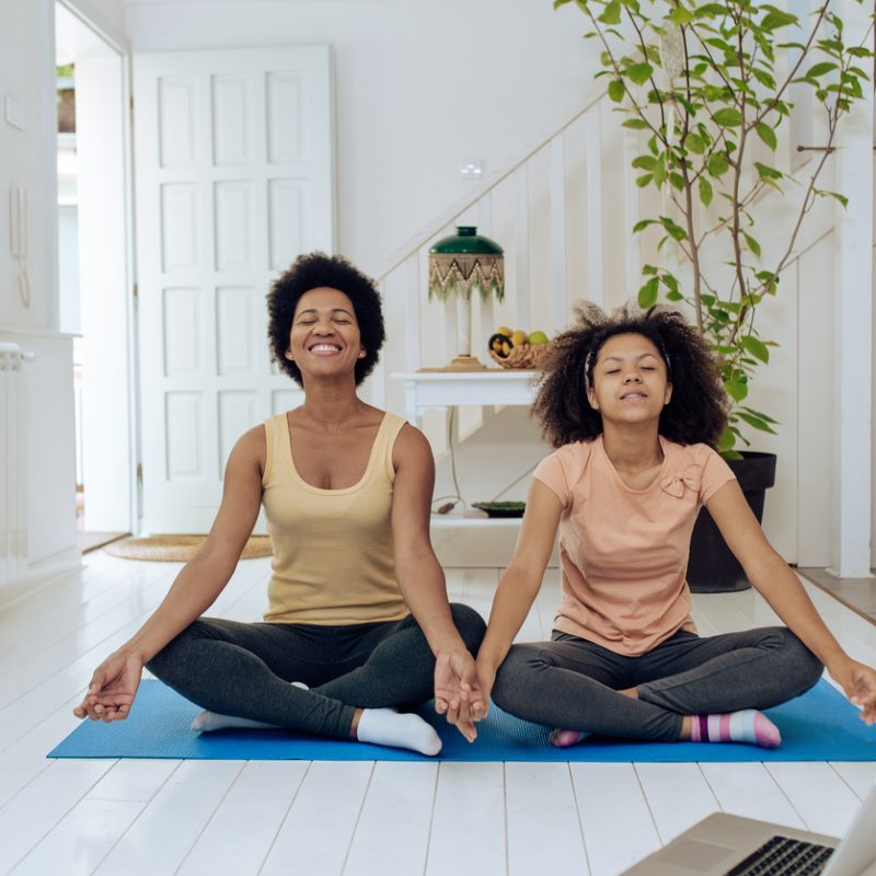 mom and daughter on yoga mat, exploring the benefits of yoga for teenage anxiety