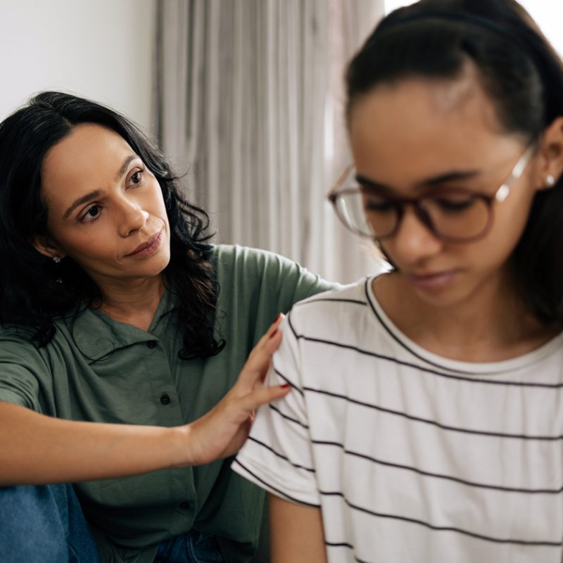 mother comforting teen daughter after learning what not to say to a depressed teenager